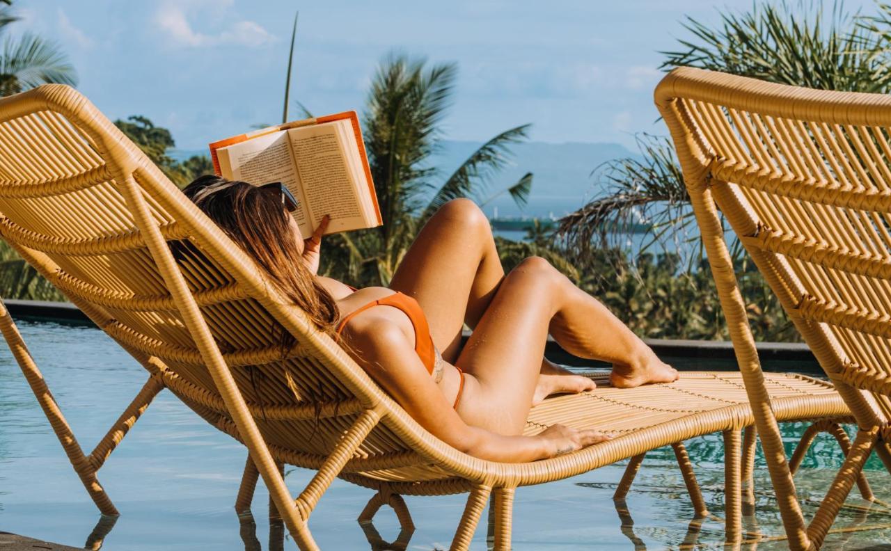 Neano Escape Hotel Manggis  Exterior photo A woman reading a book on a beach